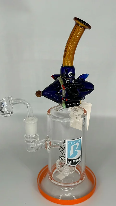 A glass pipe with a bird on top of it