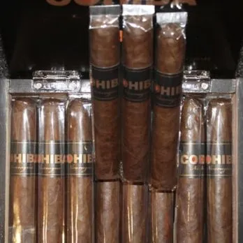 A bunch of cigars are stacked on a shelf